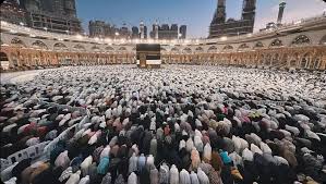 Pilgrims standing in Masjid al-Haram in Makkah facing the Kaaba during Umrah, showing calm and reflective spiritual experience
