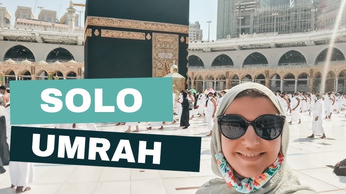 Solo female pilgrim walking safely near Masjid al-Haram in Makkah during Umrah journey with abaya and backpack in peaceful crowd