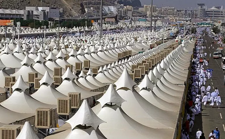 Pilgrims navigating the tent city of Mina during Hajj, using zone maps and tent numbers to locate their assigned accommodation