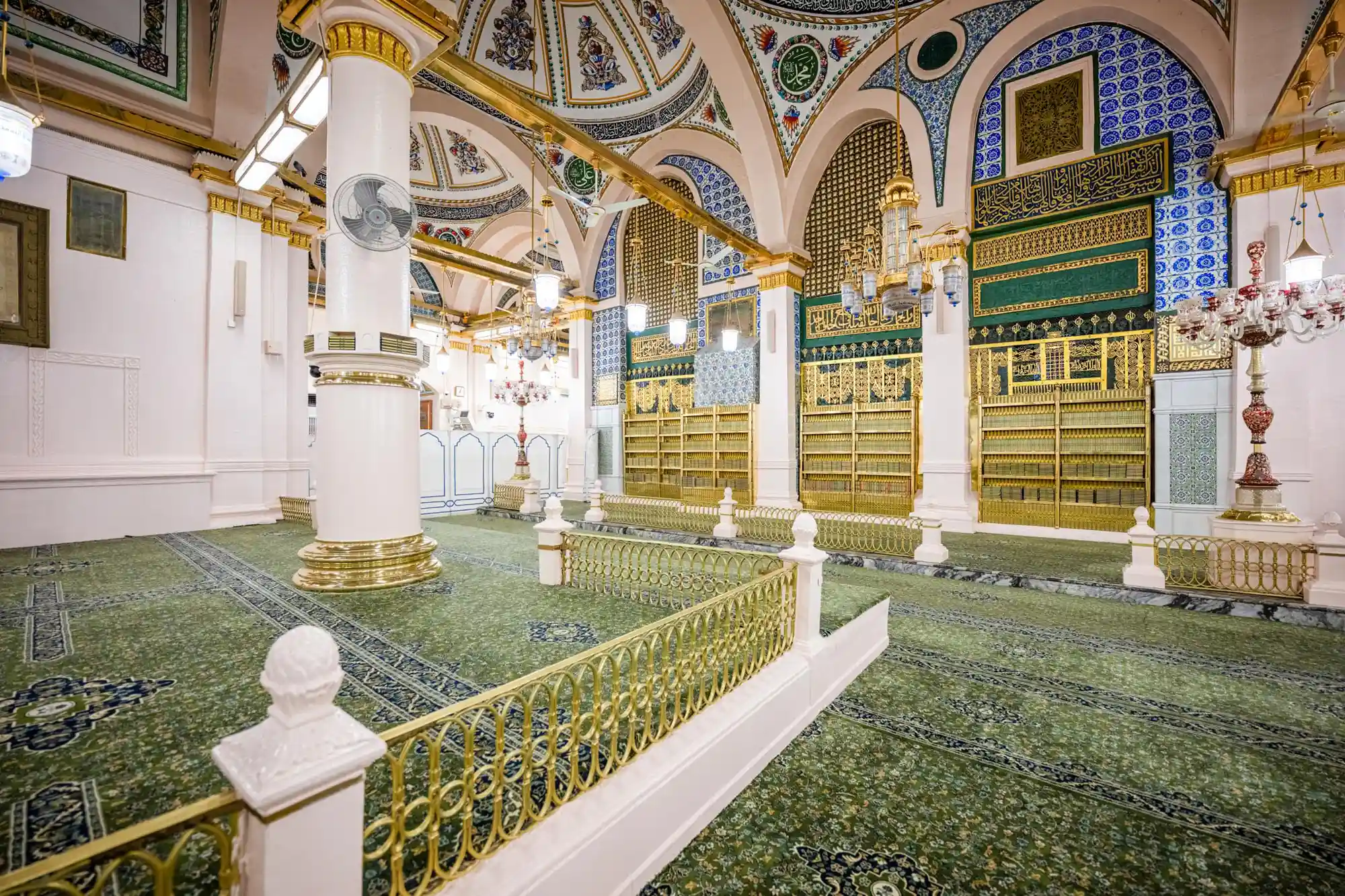 Pilgrims using Nusuk app on phone to book Rawdah visit in Masjid an-Nabawi, Madinah, with view of Prophet’s Mosque courtyard